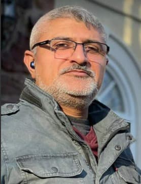 Raza - Owner, Aerotranscare Photo of Raza, owner of Aerotranscare, standing next to his company vehicle and smiling